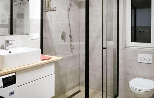 La salle de bains est pourvue d'une douche, d'un lavabo et de toilettes. dans l'établissement Beautiful Home In Sucha Huta With Kitchen, 
