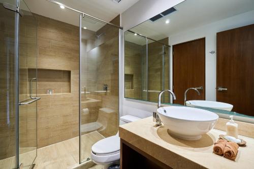 ein Bad mit einem Waschbecken, einer Dusche und einem WC in der Unterkunft Stunning Penthouse with Private Rooftop in Aldea Zama in Tulum