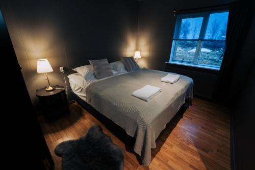 a bedroom with a bed with two towels on it at Golden Circle Luxury Cottages Lake View in Selfoss