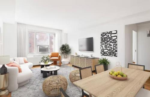 uma sala de estar com uma mesa e um sofá em Two bedroom condo in Upper West Side em Nova York