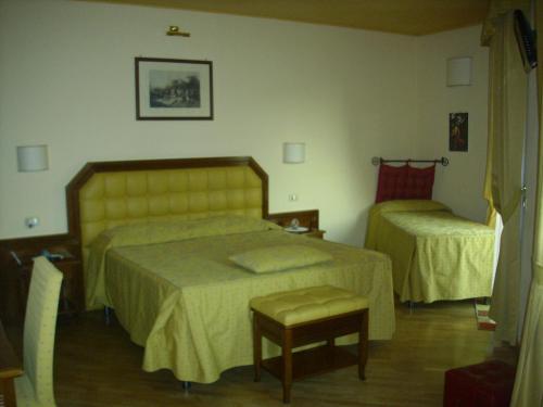 a hotel room with two beds and a chair at Chiara e Benedetta Villa degli Ulivi in Orvieto