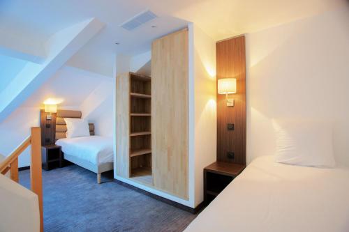 ニースにあるHôtel & Appartements Monsignyのベッドルーム1室(ベッド1台、鏡付)