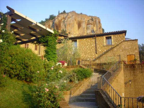 a building with stairs leading up to a mountain at Chiara e Benedetta Villa degli Ulivi in Orvieto