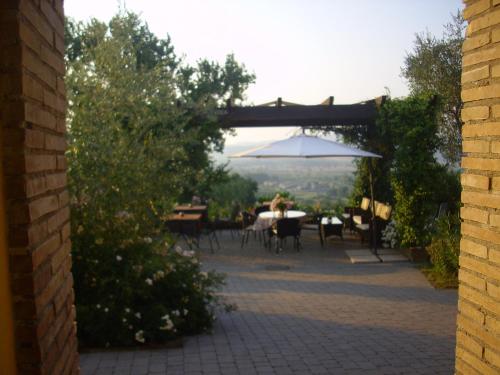 a patio with tables and chairs and an umbrella at Chiara e Benedetta Villa degli Ulivi in Orvieto