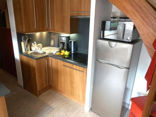 une petite cuisine avec un réfrigérateur et un évier dans l'établissement Duplex T3 à Luchon - 6 pers, télécabine, parking, wifi - FR-1-313-164, à Luchon