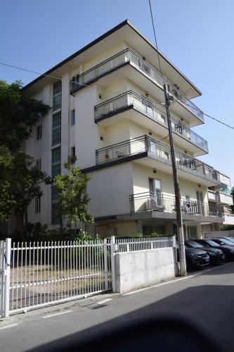 a white building with balconies and a white fence at Residence Igea in Rimini
