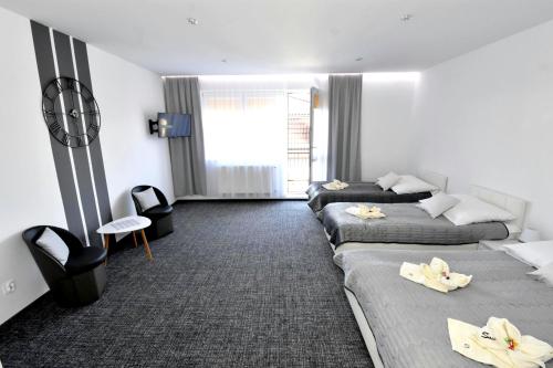 a hotel room with three beds in a row at Villa Sovita in Łeba