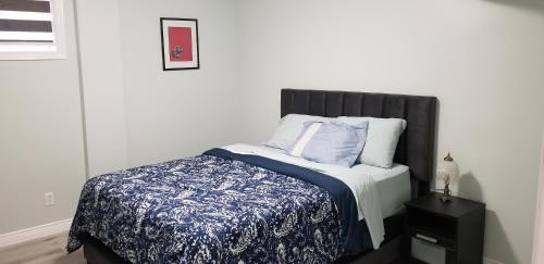 a bedroom with a bed with a blue and white blanket at 2 Bedroom Luxury Apartment in Guelph