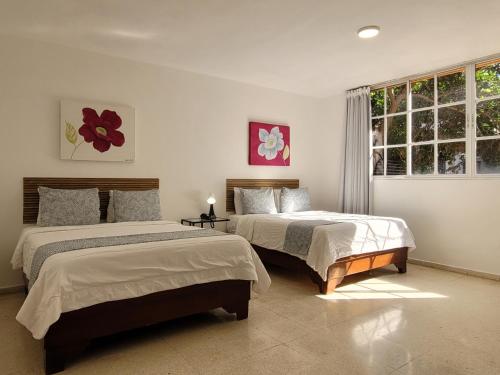 a bedroom with two beds and a window at Drake Piantini Santo Domingo in Santo Domingo