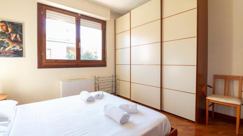 a bedroom with a white bed and a window at Villino Octagon in Elmas