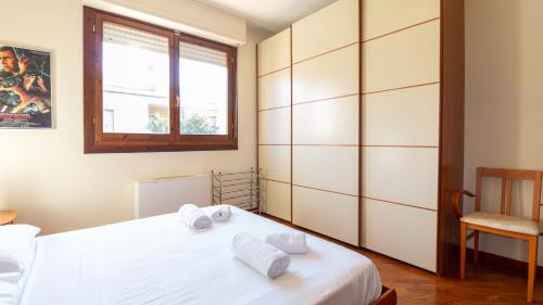 una camera con un letto bianco e una finestra di Welcomely - Villino Octagon a Elmas