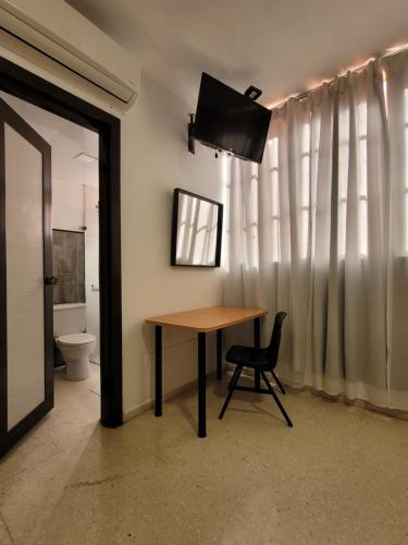 a table and a chair in a room with a toilet at Drake Piantini Santo Domingo in Santo Domingo