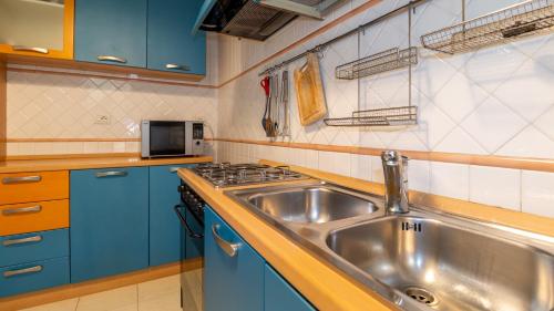 a kitchen with a stainless steel sink and blue cabinets at Villino Octagon in Elmas