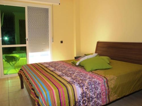 um quarto com uma cama grande e almofadas verdes em Apartment Martil em Martil