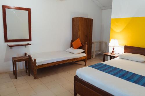 a hotel room with two beds and a mirror at Star Dambulla in Dambulla