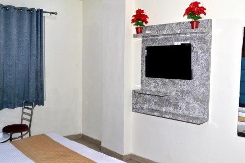 ニューデリーにあるHotel Aero Indus Near Airportの暖炉付きの部屋(壁にテレビ付)