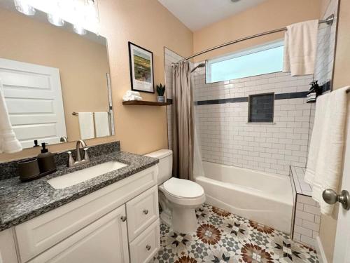 baño con lavabo y aseo y ventana en The Prairie Suite Newly Built Upscale Central, en Gainesville