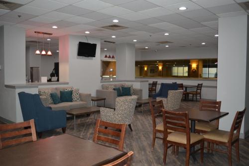 a restaurant with tables and chairs and a bar at Quality Inn & Suites East Syracuse - Carrier Circle in East Syracuse