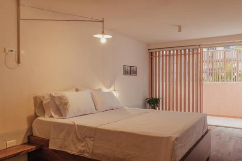 Un dormitorio con una cama grande y una ventana en NEW Cozy Duplex in Laureles with A/C and WI-FI, en Medellín