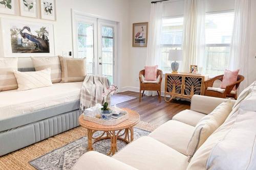 ein Wohnzimmer mit einem weißen Sofa und einem Tisch in der Unterkunft The Floridian Newly Built Dreamhome Central in Gainesville
