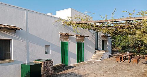 a building with green columns and a patio at LA PILA masseria salentina con piscina 6 PL in Casarano