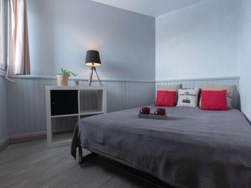 - une chambre avec un lit doté d'oreillers rouges et une télévision dans l'établissement Appartement cosy pour 4, proche pistes Saint-Lary Pla d'Adet - FR-1-296-333, à Saint-Lary-Soulan