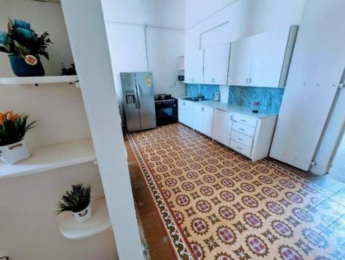 uma cozinha com armários brancos e piso em azulejo em Hostel La Española em Santo Domingo