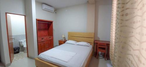 a small bedroom with a bed and a desk at Hotel Moore Iquitos in Iquitos
