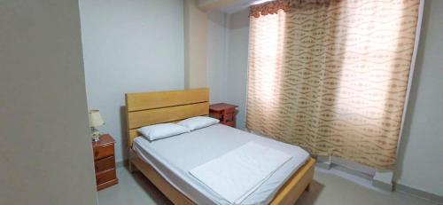a small bedroom with a bed and a window at Hotel Moore Iquitos in Iquitos