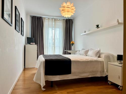 Schlafzimmer mit einem Bett und einem Kronleuchter in der Unterkunft Apartamento Ria de Foz in Foz