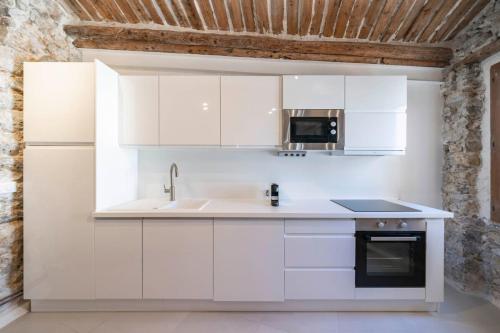 une cuisine blanche avec un évier et un micro-ondes dans l'établissement Brand new one bedroom heart of Cannes, à Cannes