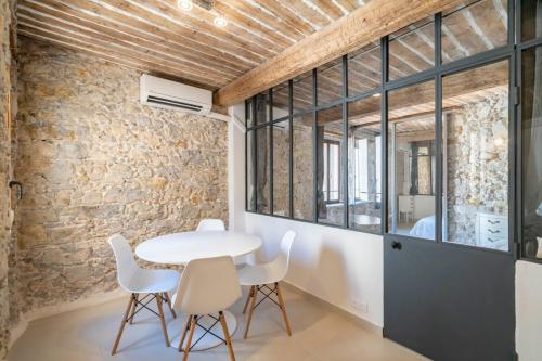 une table et des chaises dans une pièce avec un mur en pierre dans l'établissement Brand new one bedroom heart of Cannes, à Cannes