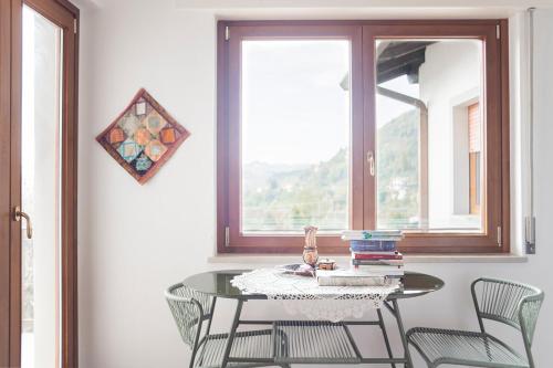 mesa y sillas en una habitación con ventana en Torlanoholidayhome it - 4 bedrooms home in the countryside - sauna, wine, swim in the creek en Nimis