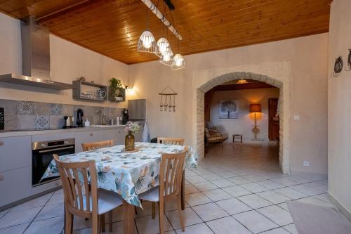 une cuisine et une salle à manger avec une table et des chaises dans l'établissement La maison des Jolicoeurs, à Saint-Christophe-sur-Guiers