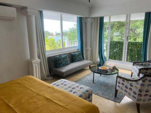 a bedroom with a bed and a couch and windows at Explora Prestige in Blue Bay