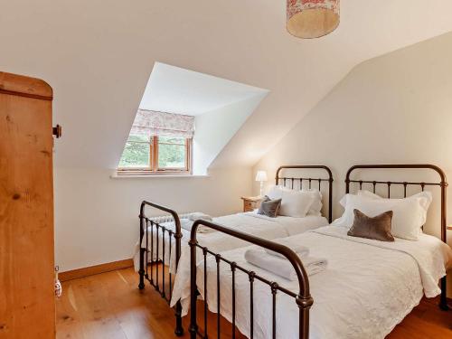 Holwell的住宿－4 Bed in Bath 27808，带窗户的客房内设有两张单人床。