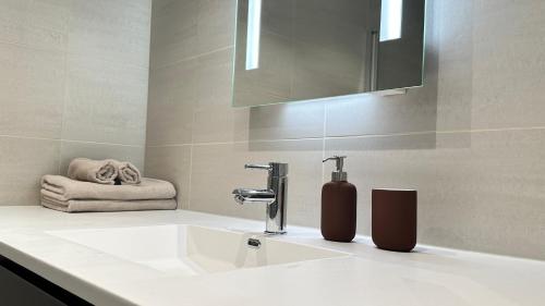 a bathroom with a white sink and a mirror at Brand new and modern apartment in Oslo center in Oslo