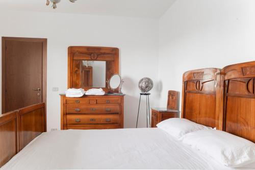 1 dormitorio con cama, tocador y espejo en 4 bedrooms home in the countryside - sauna, wine, swim in the creek, en Nimis