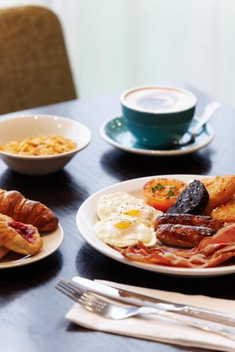 a plate of breakfast food with eggs bacon and toast at DoubleTree by Hilton Edinburgh Airport in Ingliston
