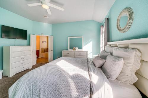 a bedroom with a white bed and a blue wall at Home with Gazebo 4 Mi to SeaWorld San Antonio! in San Antonio