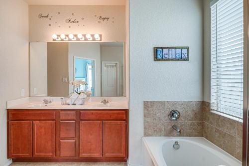a bathroom with a tub and a sink and a mirror at Home with Gazebo 4 Mi to SeaWorld San Antonio! in San Antonio