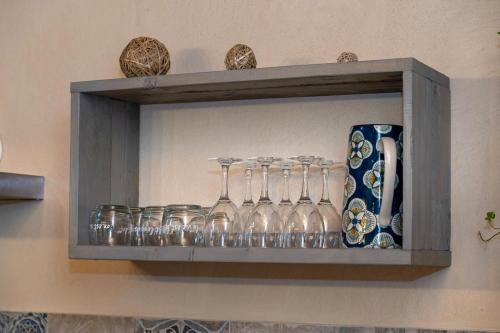 une étagère avec des verres à vin et des vases dans l'établissement La maison des Jolicoeurs, à Saint-Christophe-sur-Guiers