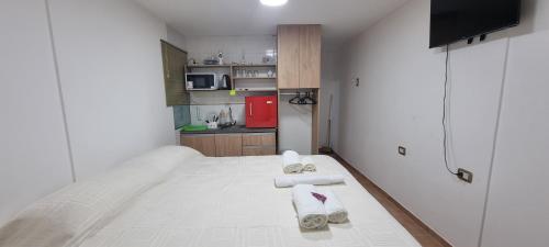 Habitación blanca con cama y toallas. en ParSur alquileres temporales Catamarca en San Fernando del Valle de Catamarca