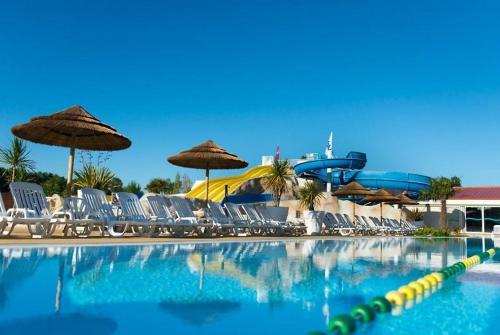 a swimming pool with chairs and a water park at mobilhome 6/8 pers. camping siblu les charmettes in Les Mathes