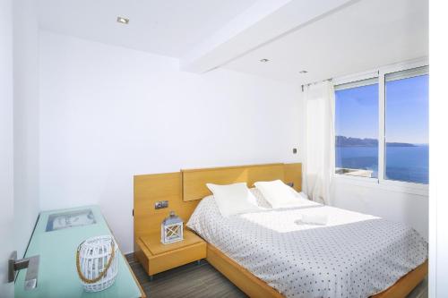 a bedroom with a bed and a large window at NEW CALM Planetcostadorada in Salou