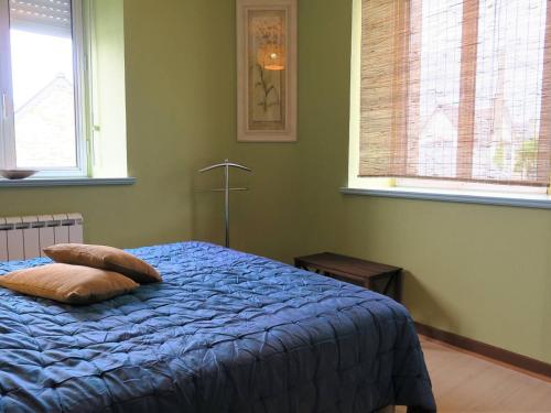 - une chambre avec un lit avec une couette bleue et 2 fenêtres dans l'établissement Appartement 1 chambre avec WIFI, parking, animaux admis à Perros-Guirec - FR-1-368-302, à Perros-Guirec