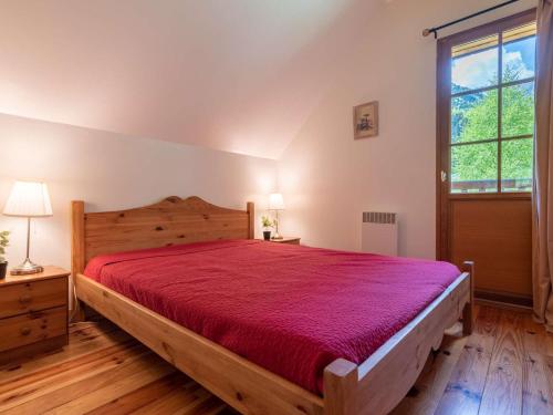 a bedroom with a wooden bed with a red bedspread at Maison Aragnouet, 5 pièces, 10 personnes - FR-1-296-343 in Aragnouet