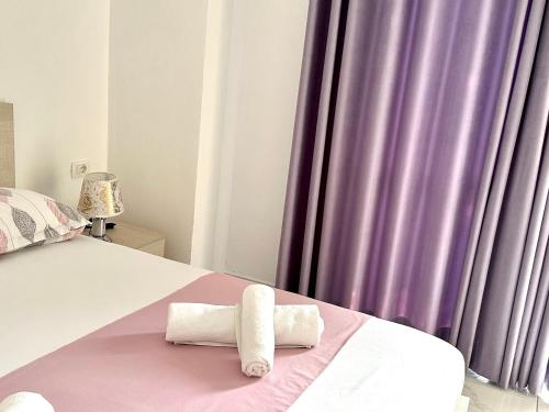 a bedroom with a bed with purple curtains at Shell Home golem 1 in Golem