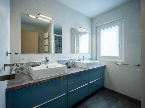 a bathroom with two sinks and a large mirror at Maison Estarvielle, 5 pièces, 10 personnes - FR-1-695-25 