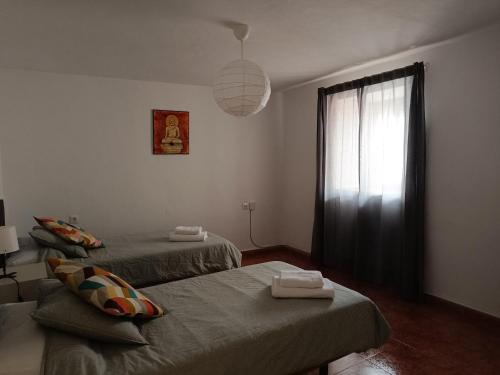 a bedroom with two beds and a window at San Acacio 22 in Ronda